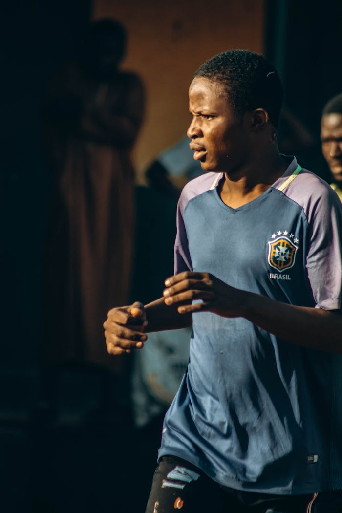Young man in a sports jersey enjoying an outdoor activity during a sunny day.